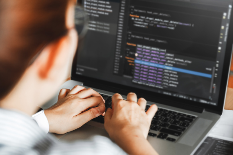 A woman coding at a computer